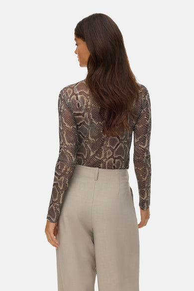 T-shirt à manches longues multicolore de Vero Moda, imprimé serpent, porté avec un pantalon taille haute neutre.