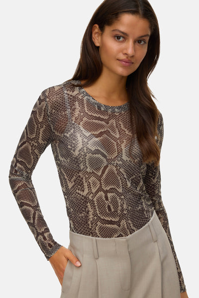 T-shirt à manches longues multicolore de VERO MODA® avec motif peau de serpent, porté avec un pantalon beige uni.
