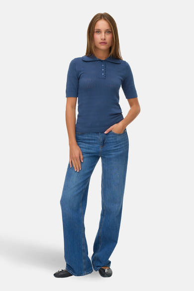 T-shirt bleu en maille ajourée de VERO MODA, porté avec un jean bleu et des ballerines noires.