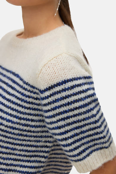 Pull à col rond bleu de VERO MODA, à rayures horizontales blanches et bleues, détail d'une boucle d'oreille.