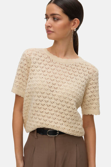 Beige T-shirt met korte mouwen van VERO MODA, in open gebreide stof, gedragen met een bruine broek met hoge taille.