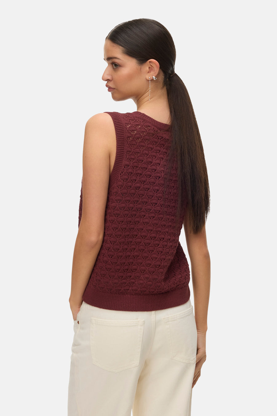 Débardeur brique de VERO MODA®, avec motif ajouré et porté avec un pantalon blanc.

