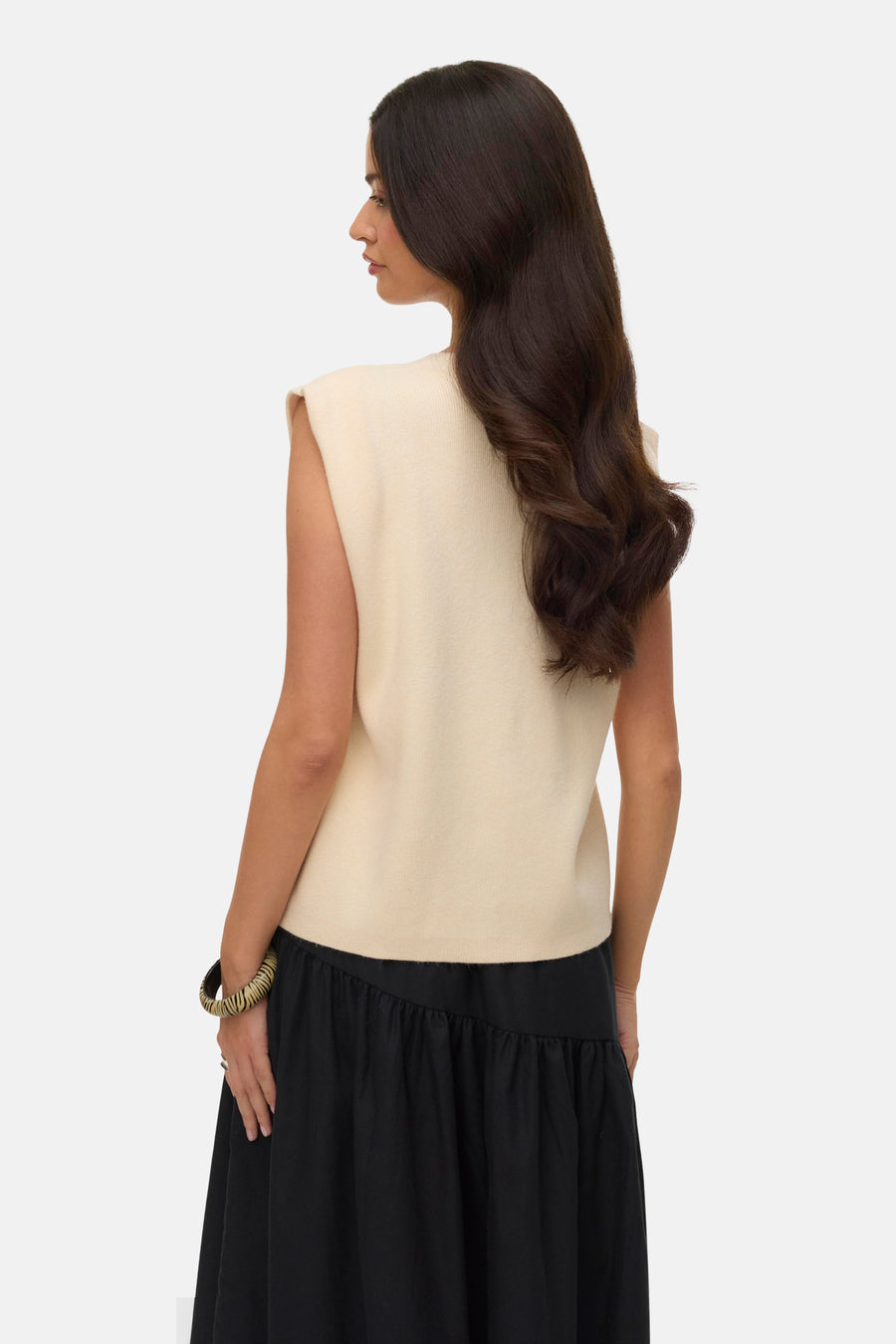 Cardigan écru de VERO MODA, porté avec une jupe noire fluide et un bracelet texturé.
