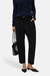 Zwarte broek van VERO MODA met een dunne riem, gedragen met een marineblauwe trui en zwarte muiltjes.