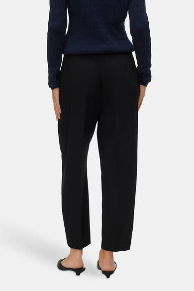 Zwarte broek van VERO MODA®, rechte pasvorm, gedragen met een marineblauwe trui en zwarte schoenen.
