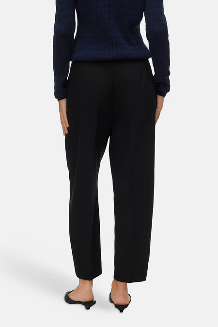 Pantalon noir de VERO MODA®, coupe droite, porté avec un pull bleu marine et des chaussures noires.