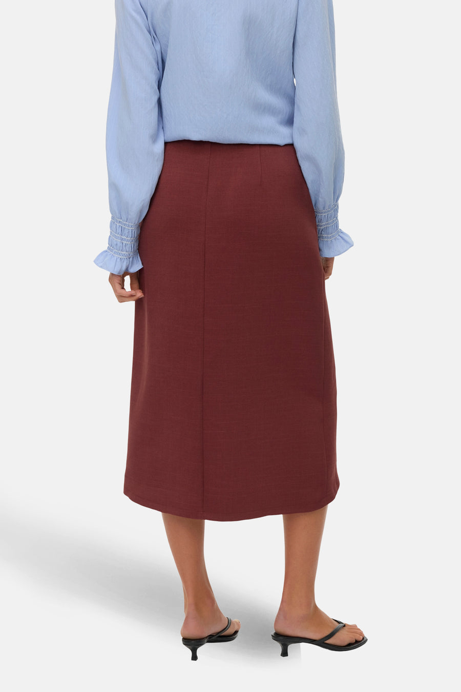 3/4 bakstenen rok van VERO MODA® met een split aan de achterkant, gedragen met een blauwe blouse met lange, gepofte mouwen.