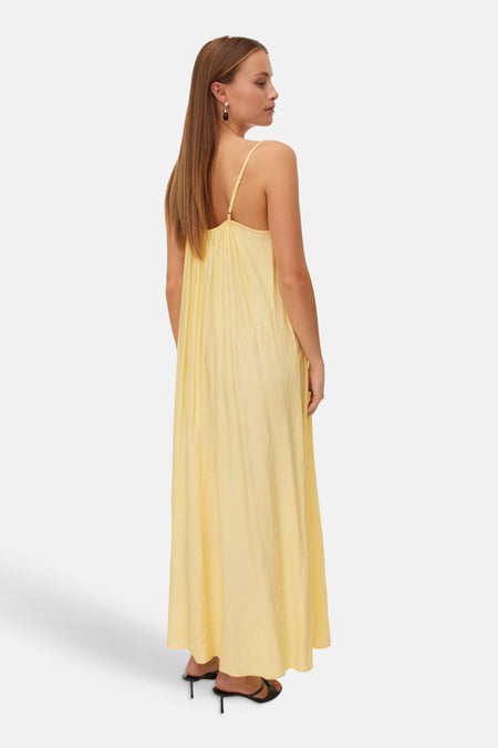 Robe longue jaune de VERO MODA® à fines bretelles, en tissu texturé, portée de dos.