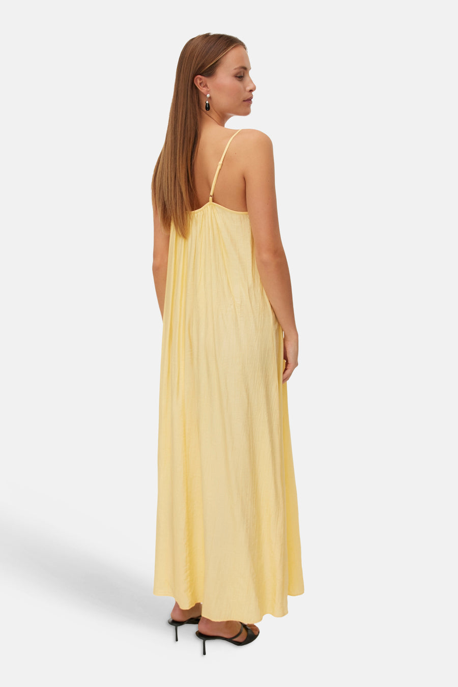 Robe longue jaune de VERO MODA® à fines bretelles, en tissu texturé, portée de dos.