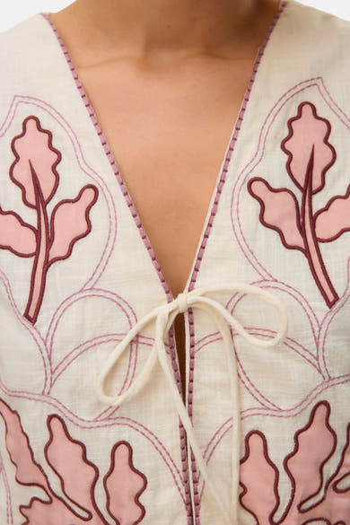 Gilet multicolore de VERO MODA® à broderies florales roses et marron sur fond crème, et encolure en V à nouer.
