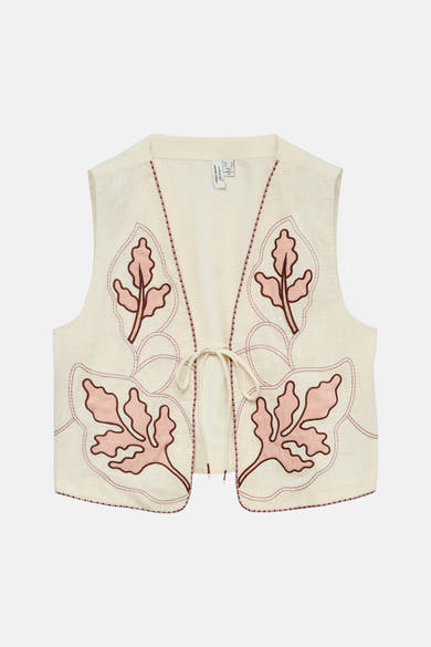 Gilet écru de VERO MODA® avec broderies de feuilles roses et marron, à nouer devant.