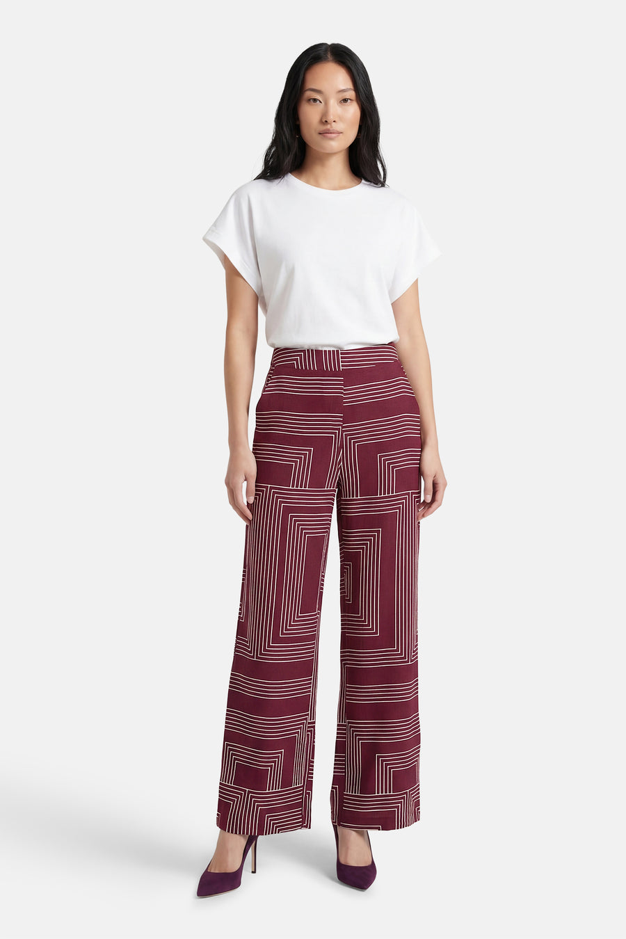Pantalon multicolore de VERO MODA®, à motif géométrique, porté avec un t-shirt blanc et des escarpins violets.
