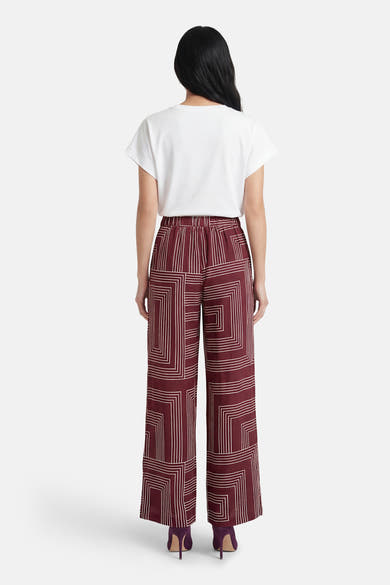 Pantalon multicolore Vero Moda, à motif géométrique, porté avec un t-shirt blanc et des talons hauts violets, vue de dos.

