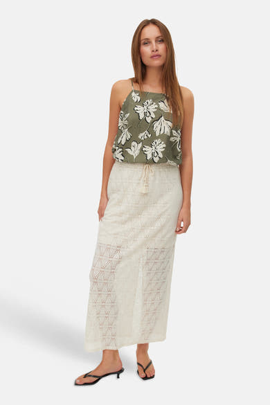 Débardeur multicolore de VERO MODA®, à motif floral, porté avec une jupe longue en tricot et des sandales noires.
