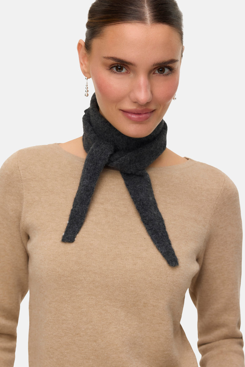 Foulard gris de VERO MODA, porté autour du cou, avec des boucles d'oreilles pendantes argentées et un pull beige.
