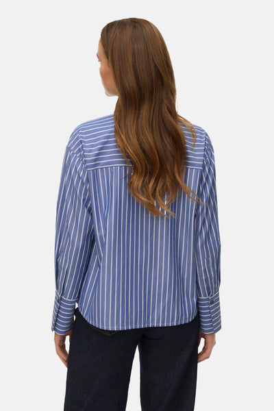 Chemise à manches longues bleue à rayures blanches par VERO MODA®, vue de dos, portée avec un pantalon bleu foncé.