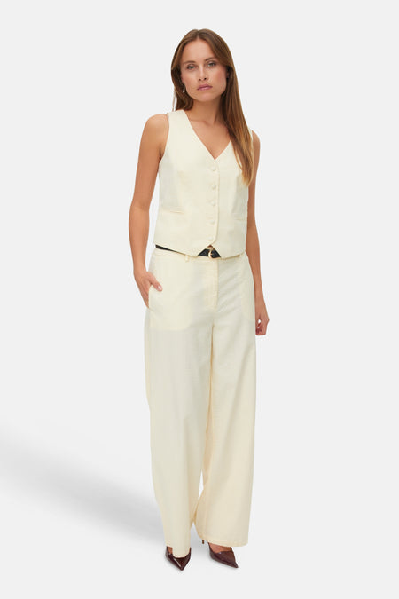 Gilet jaune de VERO MODA, porté avec un pantalon rayé coordonné et des escarpins marron.