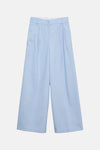 Blauwe kostuumbroek van VERO MODA®, close-up van een paspelzak en een riemlus, zichtbare stoftextuur.