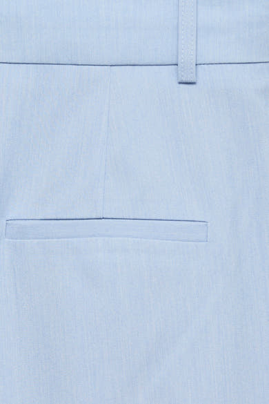 Pantalon de costume bleu de VERO MODA®, gros plan sur une poche passepoilée et un passant de ceinture, texture du tissu visible.