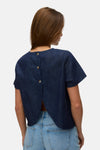 Kortemouwen blouse in donkerblauw denim van VERO MODA, gedragen met een spijkerbroekshort en sandalen met hak.