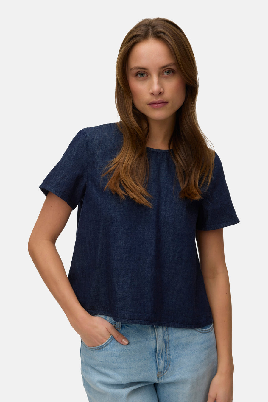 Kortemouwblouse in donkerblauw denim van VERO MODA, met lichtblauwe jeans en lang haar.