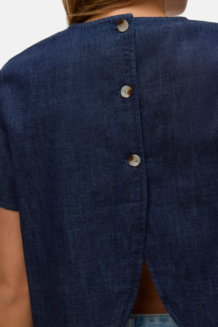 Kortemouwenblouse van donkerblauw denim van VERO MODA, met knoopsluiting aan de achterkant en een losse pasvorm.