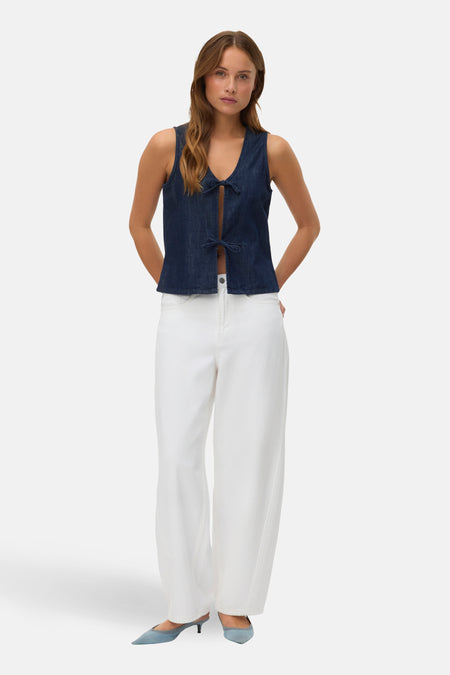 Jean en denim blanc de VERO MODA, porté avec un haut bleu noué et des escarpins bleus pointus.
