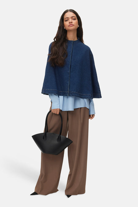 Veste en denim bleu foncé de VERO MODA, portée sur une chemise bleue et un pantalon marron, avec un sac noir.