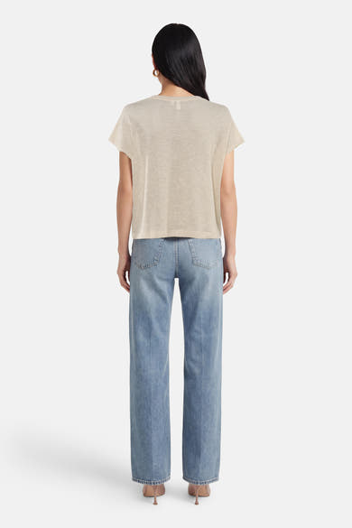 T-shirt beige à manches courtes de VERO MODA, porté avec un jean bleu taille haute et des escarpins.