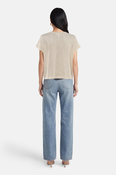 T-shirt beige à manches courtes de VERO MODA, porté avec un jean bleu taille haute et des escarpins.