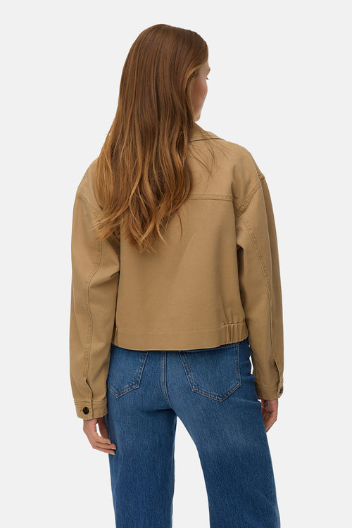Veste courte brune de VERO MODA®, vue de dos, portée avec un jean bleu.
