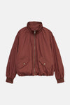 Bruin regenjas van VERO MODA® met klepzakken en ritssluiting, op neutrale achtergrond.