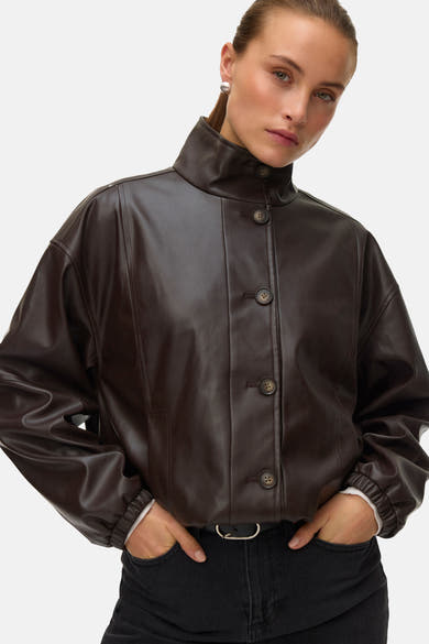 Kort bruin jack van Vero Moda, bombermodel met elastische taille, gedragen met een zwarte jeans.