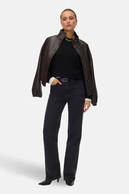 Veste courte marron de VERO MODA, portée sur un pull noir, avec jean foncé et bottines noires.