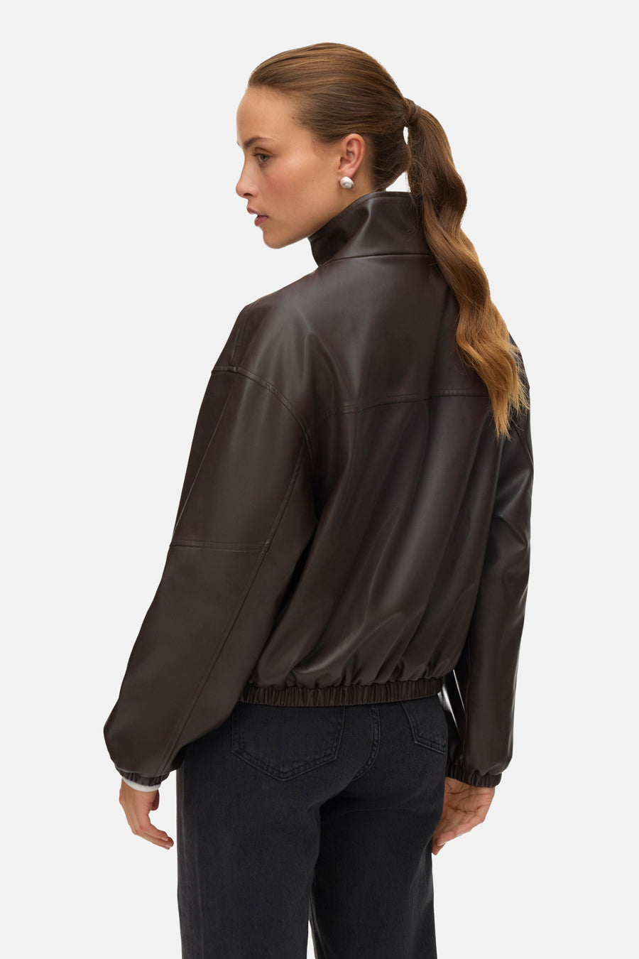 Veste courte marron de Vero Moda, coupe bomber avec taille élastiquée, portée avec un jean noir.