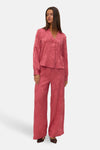 Chemisier à manches longues rose de VERO MODA® avec motif floral texturé, porté avec un pantalon assorti.