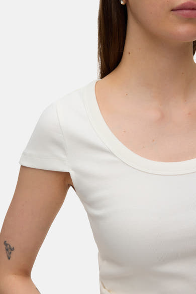 T-shirt blanc de VERO MODA à côtes fines, manches courtes et col rond, avec un tatouage de crâne de taureau sur le bras.