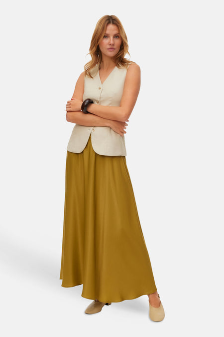 Jupe longue verte de VERO MODA®, fluide et unie, portée avec un haut sans manches.