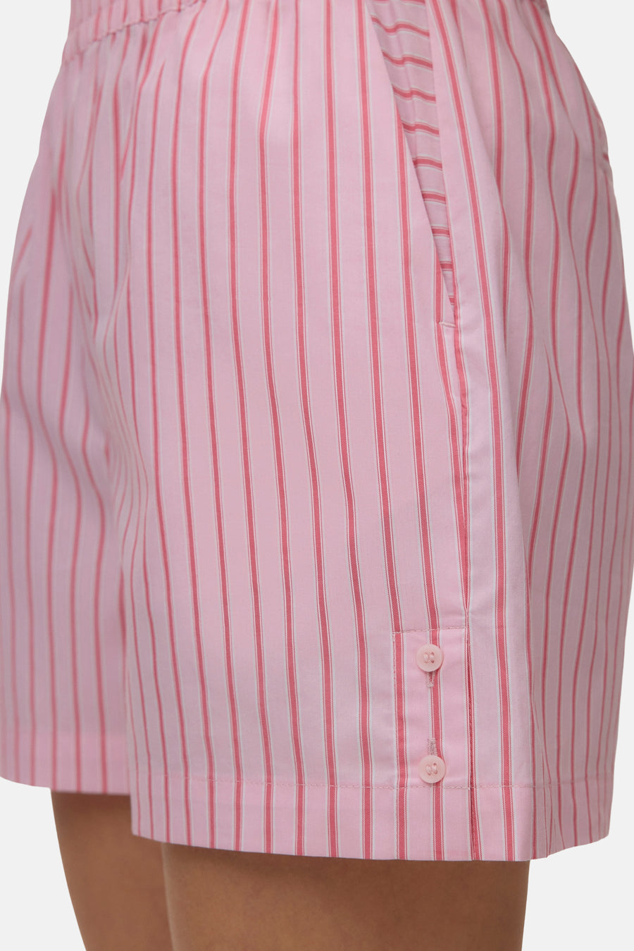 Short rose de VERO MODA® à rayures verticales roses et blanches, avec patte de boutonnage latérale et boutons roses.