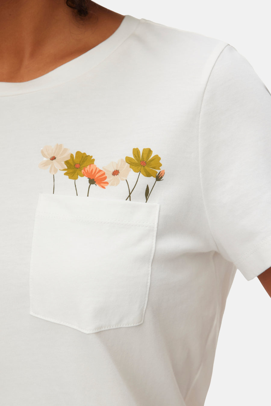 T-shirt blanc de VERO MODA® avec motif floral coloré sortant d'une poche poitrine.