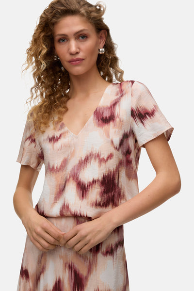 Chemisier multicolore à manches courtes de VERO MODA® avec motif abstrait rose et bordeaux, encolure en V et tissu texturé.