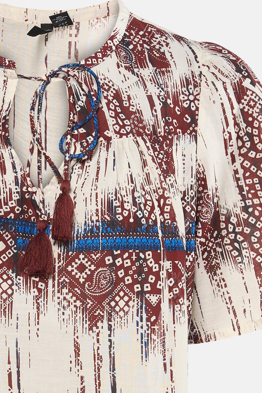 Blouse multicolore de VERO MODA® à motifs abstraits marron, beige et bleus, avec décolleté en V à pompons.