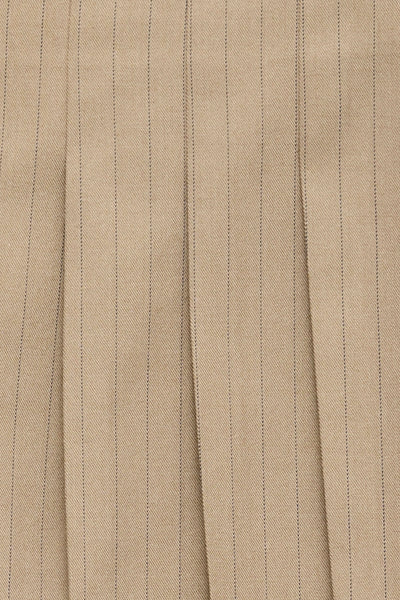 Beige pleated short skirt with fine vertical stripes, textured fabric, close-up view