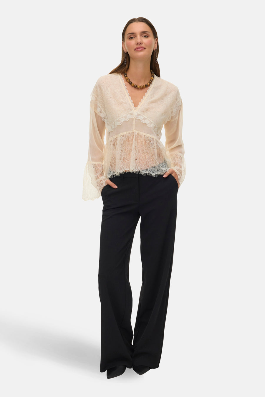 Blouse à manches longues écru de VERO MODA, avec dentelle florale et pantalon noir.