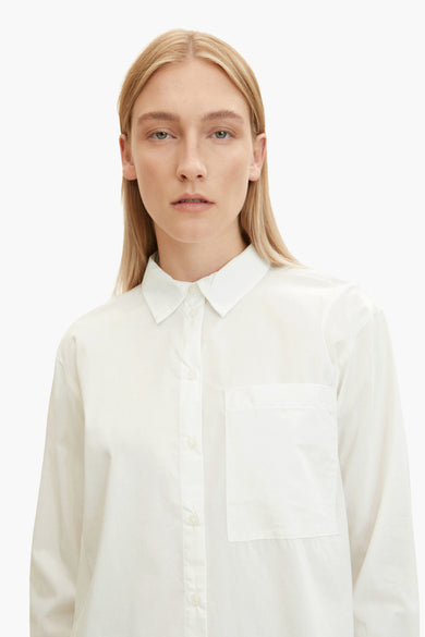 Chemisier écru à manches longues de Tom Tailor, avec poche poitrine, porté par un mannequin blond.
