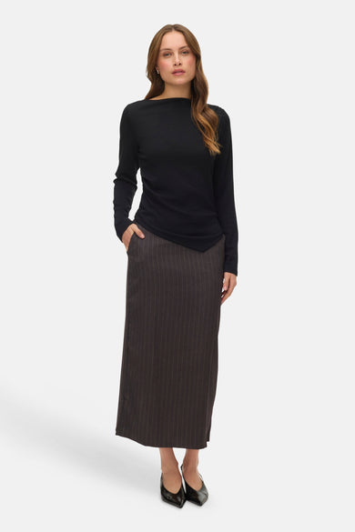 Zwart T-shirt met lange mouwen van VERO MODA, gedragen met een lange rok met fijne strepen en zwarte schoenen.