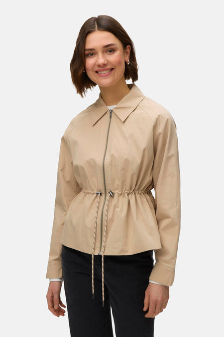 Veste courte beige de VERO MODA, avec fermeture éclair et cordon de serrage à la taille.