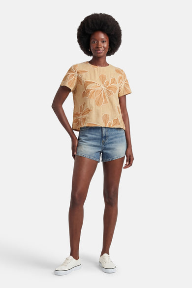 Beige blouse met korte mouwen van VERO MODA met bruin abstract bloemenpatroon, gedragen met een spijkerbroekshort en witte sneakers.