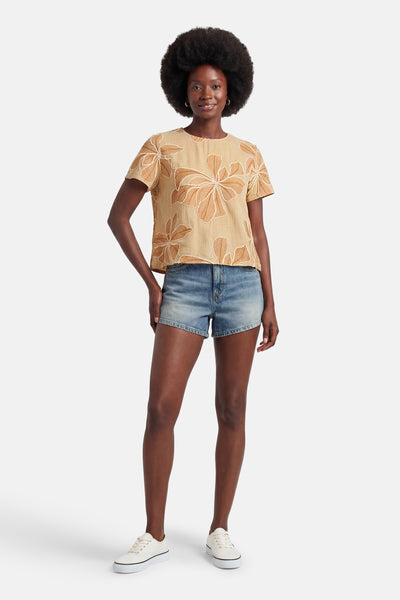 Beige blouse met korte mouwen van VERO MODA met bruin abstract bloemenpatroon, gedragen met een spijkerbroekshort en witte sneakers.