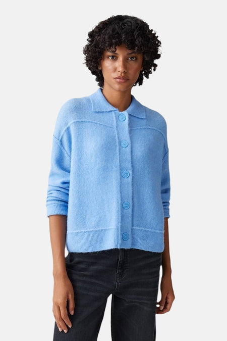 Pull bleu d'OPUS avec des boutons, porté avec un jean noir.